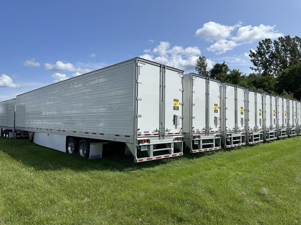 Rows of white 53-foot trailers parked on grass at the Trailerly lot